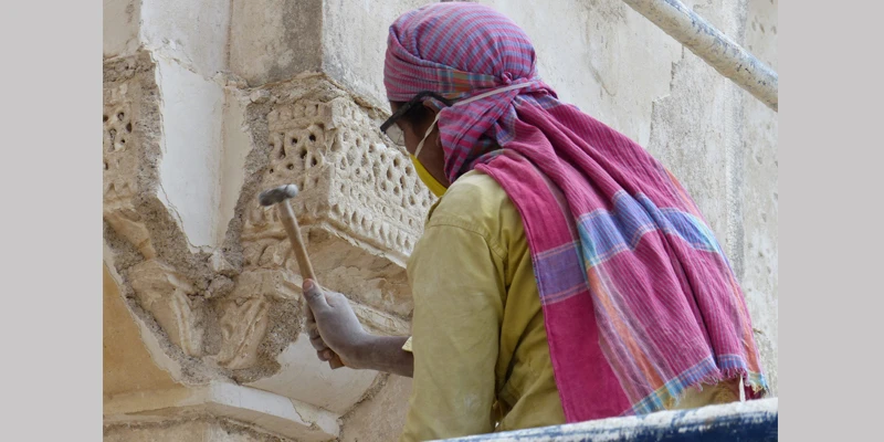 Removal of 20th century plaster revealing original stucco details from 1500s
